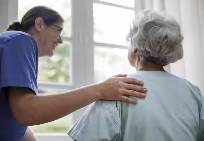 Care professional providing support to elderly patient